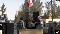 This Saturday, Oct. 21, 2017 frame grab from video, shows Syrian soldiers patrolling in the street of Qaryatayn, which was recaptured from Islamic State group militants on Saturday. 