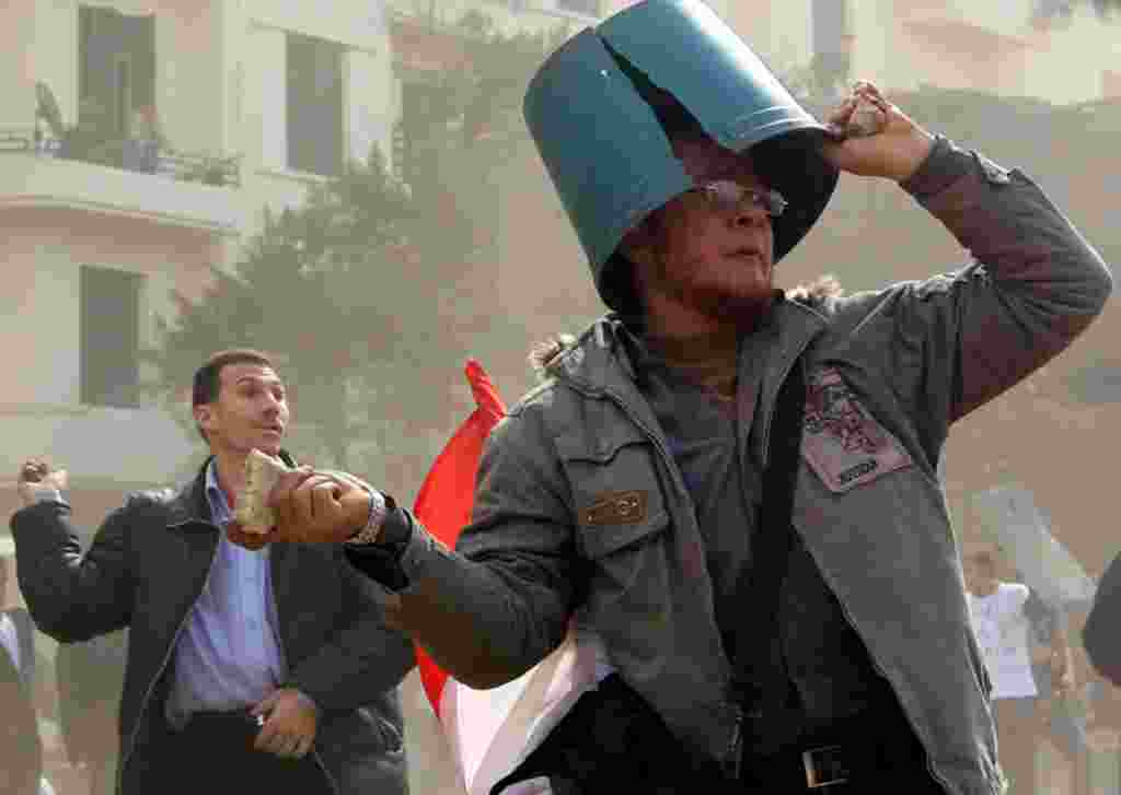 February 3: Opposition supporters throw rocks during rioting with pro-Mubarak supporters. (Goran Tomasevic/Reuters)