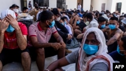 Alleged scam center workers and victims sit on the ground during a crackdown operation by the Karen Border Guard Force on illicit activity at the KK Park complex in Myanmar's eastern Myawaddy township on Feb. 26, 2025.