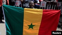 FILE - A supporter of opposition leader Ousmane Sonko, who was arrested following sexual assault accusations, attends a demonstration in front of the court in Dakar, Senegal March 8, 2021.