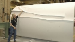 Paper is torn from a roll at the NewPage paper mill in Escanaba, Michigan