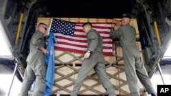 US soldiers from Marine Aircraft Group 36 adjust flags on a cargo of aid after loading it onto a cargo plane, (File)