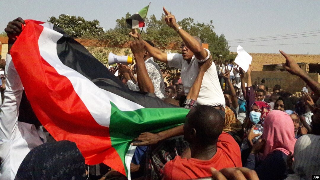 Warga Sudan yang menggelar unjuk rasa mengibarkan bendera nasional dan menyerukan slogan-slogan anti-pemerintah di Kota Omdurman, 31 Januari 2019. 