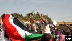 Rais wa Sudan wakiandamana na kupepea bendera ya taifa huko Omduuman. 