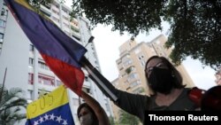 Partidarios del legislador venezolano Juan Requesens entonan eslóganes frente a su casa, el 29 de agosto de 2020, después de haber sido puedo en arresto domiciliario.