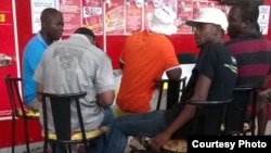 Not just a game any more … Punters discuss possible results as they follow games on TV in a sports shop. (Photo: Taurai Shava)