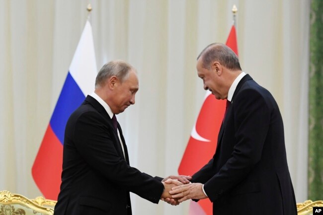Rusya Cumhurbaşkanı Vladimir Putin ve Cumhurbaşkanı Recep Tayyip Erdoğan İran'da yapılan üçlü Suriye zirvesinde tokalaşırken, 7 Eylül 2018.