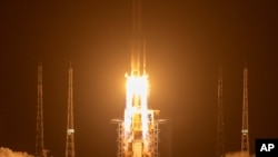 FILE - A Long March-5 rocket carrying the Chang'e 5 lunar mission lifts off at the Wenchang Space Launch Center in Wenchang in southern China's Hainan province, Nov. 24, 2020.