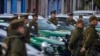 Policías chilenos junto a sus patrullas durante una ceremonia de inicio del programa "Calles sin violencia" patrocinado por el gobierno, en Santiago de Chile, el lunes 24 de abril de 2023.