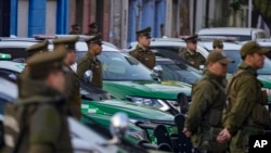 Policías chilenos junto a sus patrullas durante una ceremonia de inicio del programa "Calles sin violencia" patrocinado por el gobierno, en Santiago de Chile, el lunes 24 de abril de 2023.