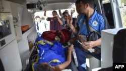 Members of an Indonesian medical team transport an earthquake survivor in an ambulance in Lombok on July 29, 2018.