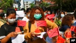 FILE - Anti-coup protesters place defaced Chinese flags on watermelon, April 13, 2021, in Yangon, Myanmar. The group opposed trade with China, saying it affected local prices. Analysts today say Beijing's perceived support for Myanmar's junta has frustrated many.