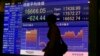 A man walks by an electronic stock indicator of a securities firm in Tokyo, April 28, 2016. 