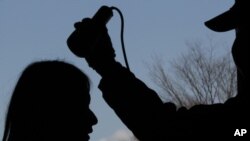 Yumi Saitou, who lives in Fukushima, is silhouetted as she is tested for possible nuclear radiation at an evacuation center in Fukushima, northern Japan, March 28, 2011.