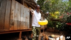 Bernard Mwololo feeds chickens at the Nyumbani Children's Home in Nairobi, Kenya, on Aug. 15, 2023. Benard, who has lived most of his life at the orphanage after his parents died of AIDS, believes he is alive only because of antiretroviral drugs made possible by U.S. assistance.