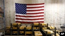 FILE - Gold bars are stacked in a vault at the U.S. Mint in West Point, N.Y., on July 22, 2014.