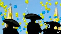 ARSIP - Anggota band mariachi memainkan musiknya sementara balon-balon beterbangan pada acara ulangtahun berdirinya Kota Guadalajara yang ke-464 (14/2/2006). Katedral Guadalajara tampak di latar belakang. (foto: AP Photo/Guillermo Arias)