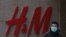 A man wearing a face mask walks by a Swedish fashion brand H&M store outlet in Beijing, March 25, 2021. 