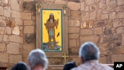 The Apache Christ painting hangs behind the altar of St. Joseph Apache Mission church in Mescalero, New Mexico, July 13, 2024. The painting was the forefront of an episode between the community and the local Diocese when it was removed by the church's then-priest.