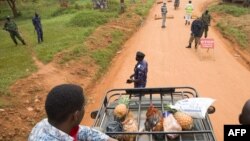 Supporters of the opposition leader Robert Kyagulanyi, also known as Bobi Wine, are blocked by police officers at checkpoint on a street leading to Kyagulanyi's house, as they bring food to deliver in Magere, Jan. 21, 2021.