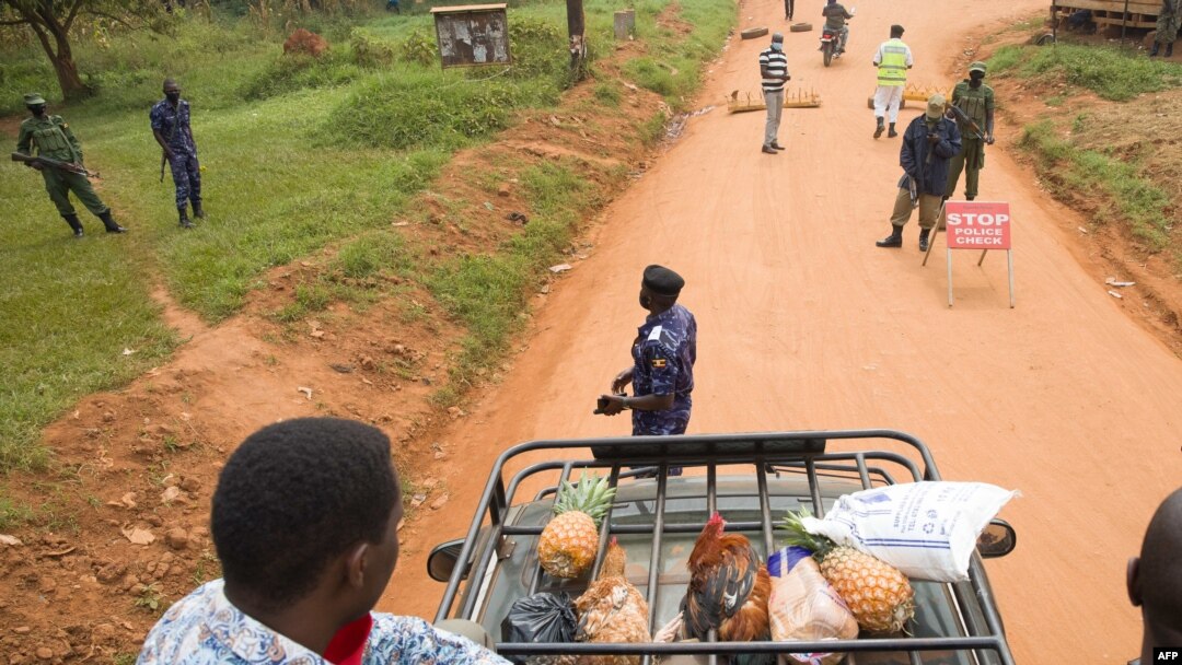 Supporters of the opposition leader Robert Kyagulanyi, also known as Bobi Wine, are blocked by police officers at checkpoint on a street leading to Kyagulanyi's house, as they bring food to deliver in Magere, Uganda, Jan. 21, 2021.