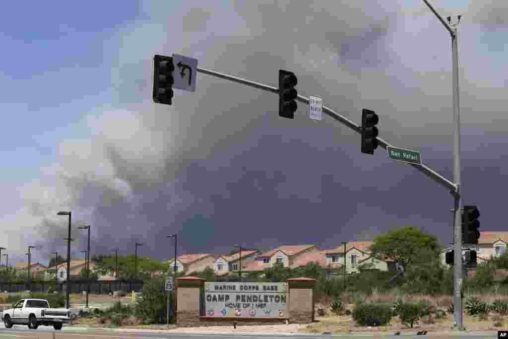 Smoke plumes rise behind the Marine Corps Base Camp Pendleton entrance in Oceanside, California, May 16, 2014.