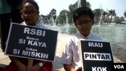 Dua siswa sekolah dasar di Jakarta dalam protes menentang kebijakan rintisan sekolah bertaraf internasional (RSBI). (Foto: Dok)