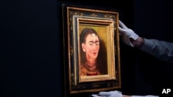 ARCHIVO - Una persona ajusta "Diego y yo" de Frida Kahlo en una exhibición en la casa de subastas Sotheby's durante una vista previa para la prensa de la subasta Modern Evening, el 5 de noviembre de 2021, en Nueva York.