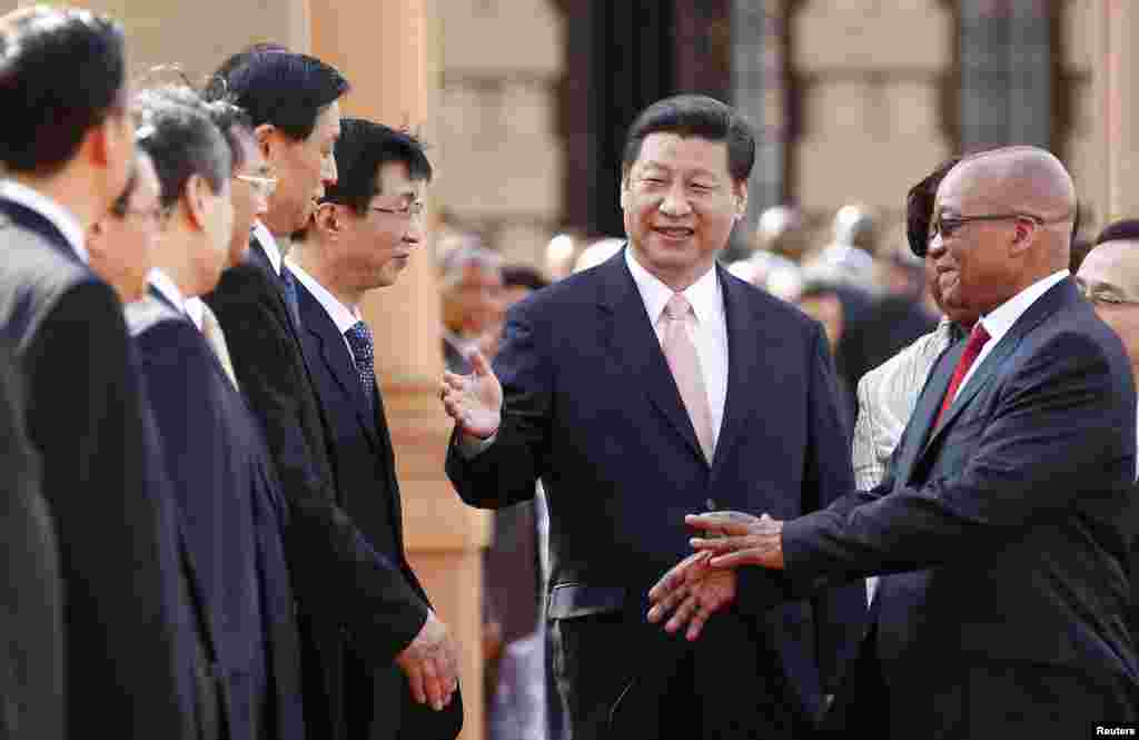 Presiden Afrika Selatan Jacob Zuma (kanan) diperkenalkan pada delegasi China oleh Presiden China Xi Jinping (tengah) dalam kunjungan kerja di Pretoria, Afrika Selatan, 2013. (Reuters/Siphiwe Sibeko)