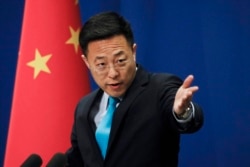 FILE - Chinese Foreign Ministry new spokesman Zhao Lijian gestures as he speaks during a daily briefing at the Ministry of Foreign Affairs office in Beijing, Feb. 24, 2020.