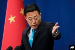 FILE - Chinese Foreign Ministry new spokesman Zhao Lijian gestures as he speaks during a daily briefing at the Ministry of Foreign Affairs office in Beijing, Feb. 24, 2020.