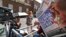 A news cameraman reads a newspaper across from St. Mary's Hospital's exclusive Lindo Wing in London, July 22, 2013. 