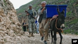 Afghan election workers use donkeys to transport ballot boxes and election materials to polling stations as walking through Mazar-i-Sharif to Kishindih district in Balkh province, Afghanistan, April 3, 2014. 