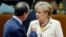FILE - Germany's Chancellor Angela Merkel (R) and France's President Francois Hollande arrive for a working session during an EU summit in Brussels, Oct. 24, 2014. 
