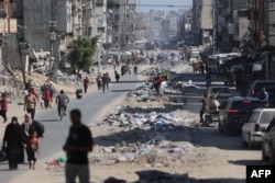 Palestinians carry their belongings as they flee areas north of Gaza City in the northern Gaza Strip on Oct. 12, 2024.