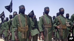 A February, 2011 photo shows al-Shabab fighters on parade with their guns during military exercises on the outskirts of Mogadishu, Somalia. 