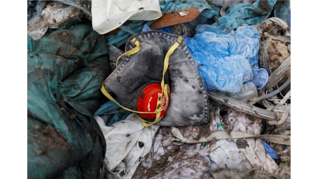 FILE - A discarded N95 protective face mask lies amongst other bits of disposed medical waste at a landfill site, during the coronavirus disease (COVID-19) outbreak, in New Delhi, India, July 22, 2020.