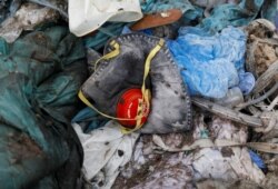 FILE - A discarded N95 protective face mask lies amongst other bits of disposed medical waste at a landfill site, during the coronavirus disease (COVID-19) outbreak, in New Delhi, India, July 22, 2020.
