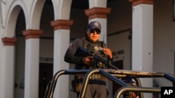 ARCHIVO. Un policía vigila el Ayuntamiento de Maravatío, estado de Michoacán, México, el martes 27 de febrero de 2024. AP