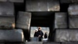 A mourner is seen through a barricade in Kyiv&#39;s Independent Square. 