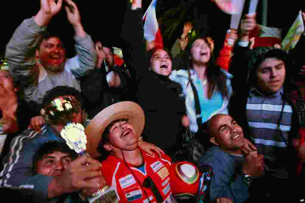 October 13: Residents celebrate when Florencio Avalos became the first miner to reach the surface, while watching the rescue on a large screen in a public square in Copiapo October 13, 2010. (Mariana Bazo/Reuters)