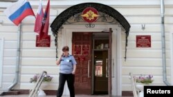 An officer walks outside a Federal Migration Service office in central Moscow, July 16, 2013.