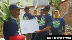 Badru Hidayat (kiri) dan Fauzi (tengah) menunjukkan rencana pembuatan bengkel produksi untuk meningkatkan kapasitas produksi, di Gedebage, Bandung, 7 Februari 2019. (Foto: Rio Tuasikal/ VOA) 