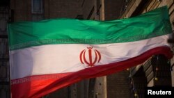 Gambar bendera Iran di depan gedung Kementerian Luar Negeri Iran di Teheran 23 November 2009. (Foto: REUTERS/Morteza Nikoubazl)