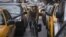 A commuter cycles past a long line of vehicles waiting to get fuel from a gas station in Midtown Manhattan, New York, November 2, 2012. 