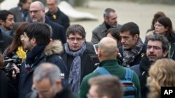 Pemimpin Catalan yang dilengserkan, Carles Puigdemont (tengah) berjalan di taman bersama anggota parlemen Catalan terpilih dari partai "Bersama untuk Catalonia" di Brussels, 12 Januari 2018. 