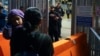 FILE - Paula, foreground, of Guatemala, holds her daughter as she asks U.S. Customs and Border Protection officials about new asylum rules at the San Ysidro Port of Entry in Tijuana, Mexico, May 11, 2023.