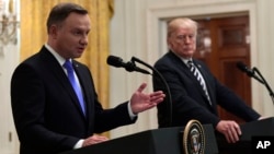 FILE - President Donald Trump, right, listens as Polish President Andrzej Duda, left, speaks during a joint news conference in the East Room of the White House in Washington, Sept. 18, 2018. 