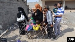 Iraqi families fleeing Islamic State (IS) group advance in their towns arrive to take refuge in a Kurdish-controlled area in Mullah Abdullah, some 25 kms west of Kirkuk, Oct. 15, 2014.