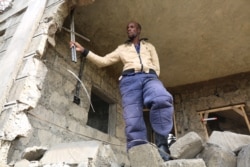 Daniel Ndungu, 42, stands at his demolished home in Ruai area in Nairobi. (Mohammed Yusuf/VOA)